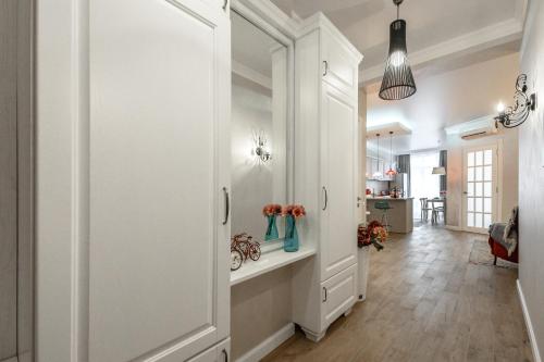 a hallway with a white door with vases on a shelf at Arkadia Plaza Design Apartment in Odesa
