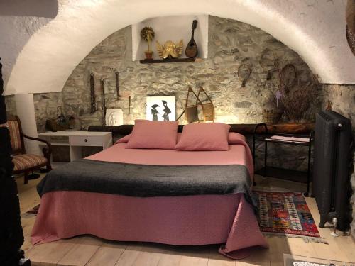 sypialnia z dużym łóżkiem w kamiennej ścianie w obiekcie Appartamento Country House Menaggio w mieście Menaggio
