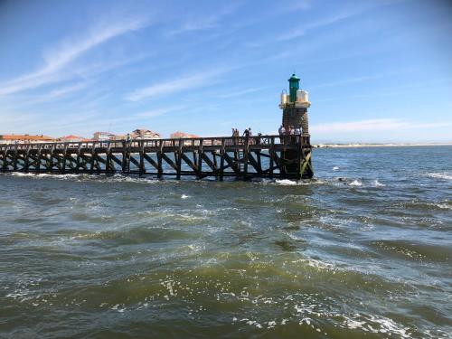 a lighthouse on a pier in the water at Centre de vacances CAPLANDES in Capbreton