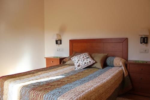 1 dormitorio con 1 cama grande y cabecero de madera en As Casas das Minas, en Zobra