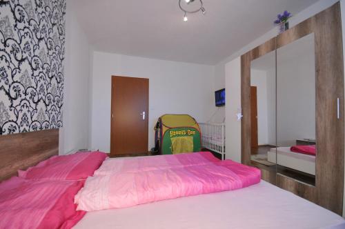 a bedroom with a large bed with a pink blanket at Apartmán Tatry-Nová Lesná in Nová Lesná
