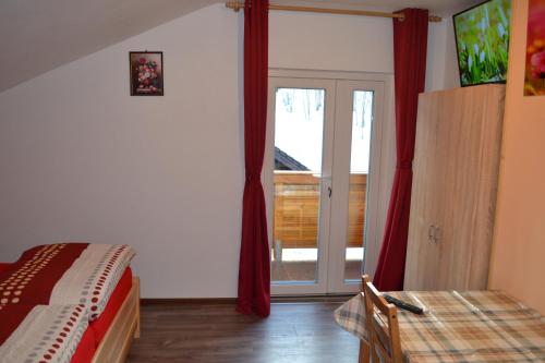 a bedroom with a bed and a sliding glass door at Apartment Holiday Lungötz in Annaberg im Lammertal
