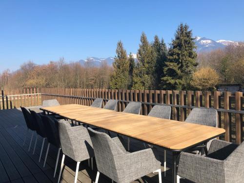 a wooden table and chairs on a deck at Swiss Lake Lodge in Noville
