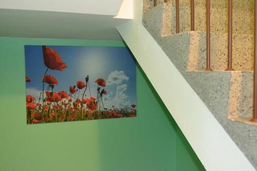 a picture of a field of red flowers on a wall at Apartment Holiday Lungötz in Annaberg im Lammertal