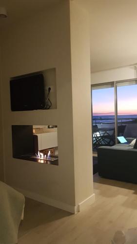 a living room with a fireplace with a tv above it at Gava Ocean View in Gavà
