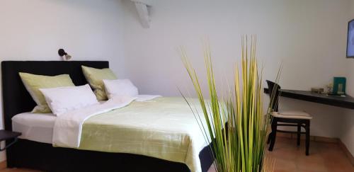 Un dormitorio con una cama con sábanas blancas y una planta en Wipperaublick in der Oldenstädter Wassermühle en Uelzen