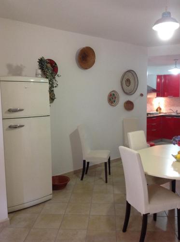a kitchen with a white refrigerator and a table and chairs at Bacio di sole Apartment and rooms in Pula