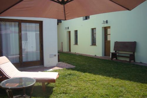 a patio with a table and a chair and an umbrella at Lanita B&B in Càbras