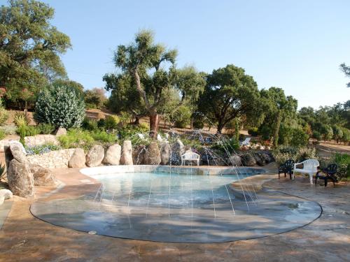 a swimming pool with a fountain in a park at Camping La Vetta in Porto-Vecchio