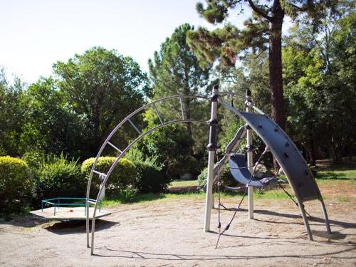 une aire de jeux avec un toboggan et un trampoline dans l'établissement Camping La Vetta, à Porto-Vecchio