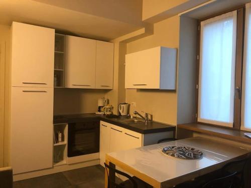 a small kitchen with white cabinets and a table at CASA FEDERICO in Dorio