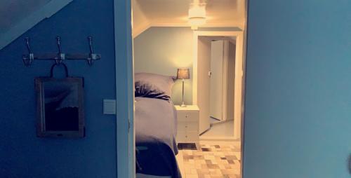 a bedroom with a bed and a blue wall at Narnia Lodge Lofoten in Gimsøy