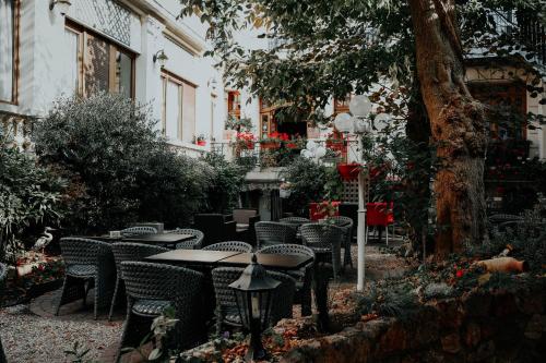 an outdoor patio with tables and chairs and a tree at Hôtel Crystal Reims Centre in Reims