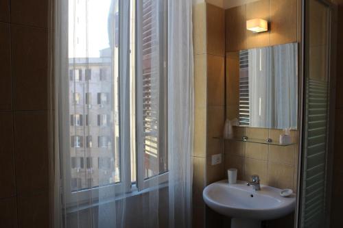 La salle de bains est pourvue d'un lavabo et d'une fenêtre. dans l'établissement Home 57 Relais, à Rome