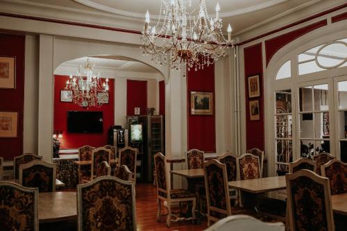 a dining room with red walls and a table and chairs at Hôtel Crystal Reims Centre in Reims
