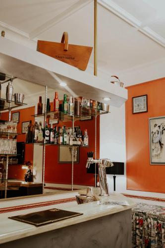 a kitchen with orange walls and a counter with a sink at Hôtel Crystal Reims Centre in Reims