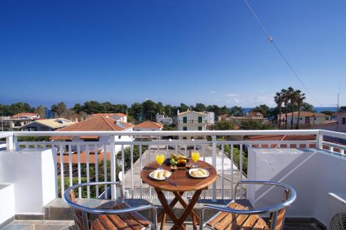 a table and chairs on a balcony with a view at Syriti Studios in Skala Kefalonias