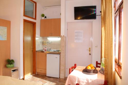 a small kitchen with a table with a bowl of fruit on it at Guest House Tomanovic in Herceg-Novi