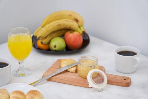 a table with a plate of fruit and a glass of orange juice at Syriti Studios in Skala Kefalonias