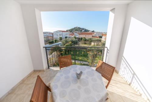 ein Tisch und Stühle auf einem Balkon mit Aussicht in der Unterkunft Perla Alba Apartments in Tribunj