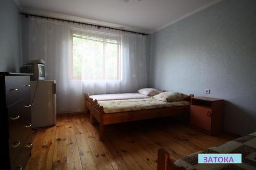 a small bedroom with a bed and a window at Затока in Svityazʼ