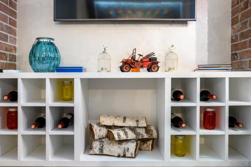 a white shelf with wine bottles and a toy car on it at Arkadia Plaza Design Apartment in Odesa