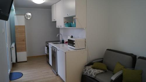 a small kitchen with a couch and a microwave at Apartament Bajka in Rumia