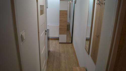 a hallway with an open door and a hallway with a wooden floor at Apartament Bajka in Rumia