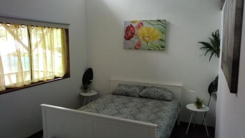 1 dormitorio con 1 cama y una foto en la pared en Centro Ananda en Guápiles