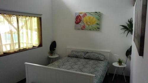 a bedroom with a bed and a picture on the wall at Centro Ananda in Guápiles