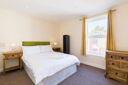 a bedroom with a large bed and a window at Leamington Spa Town House 2-Bed, 2 Bath in Leamington Spa