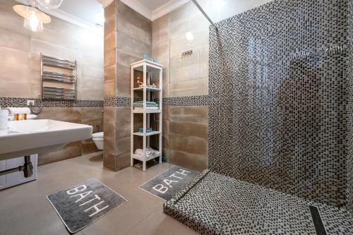 a bathroom with a shower and a sink at Arkadia Plaza Design Apartment in Odesa