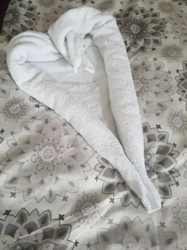 a towel in the shape of a heart laying on a bed at Monteurwohnung Schinderhannes in Miehlen