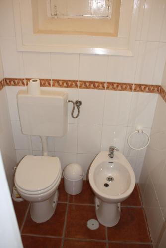 a small bathroom with a toilet and a sink at Penhas da Saúde in Penhas da Saúde