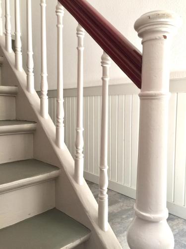a stairway with white railings and a stair case at Appartment Chupferschmied - Wohlfühlen im Altstadtambiente in Schopfheim