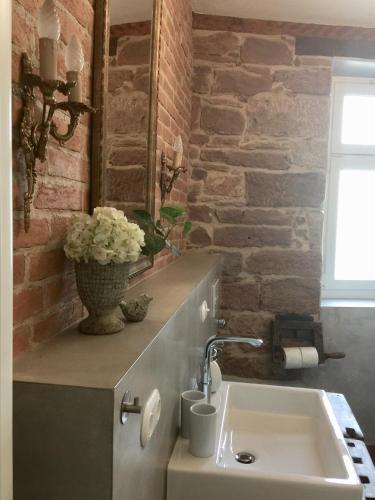 a bathroom with a sink and a brick wall at Appartment Chupferschmied - Wohlfühlen im Altstadtambiente in Schopfheim