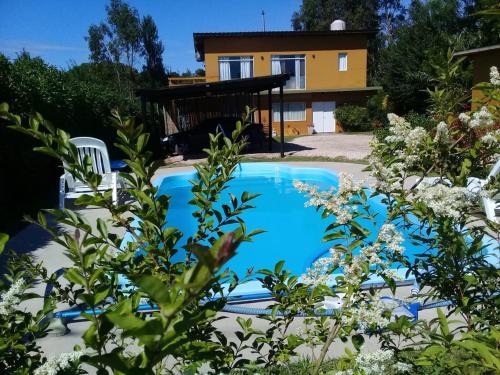 una piscina con una casa en el fondo en Mini Complejo El Encuentro en Sierra de los Padres