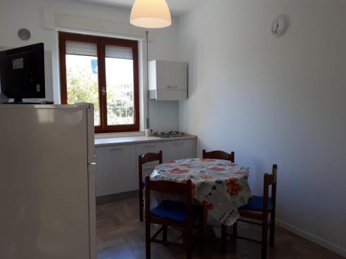 cocina con mesa, sillas y ventana en Appartamento rimodellato seconda fila mare centro di Cupra Marittima, en Cupra Marittima