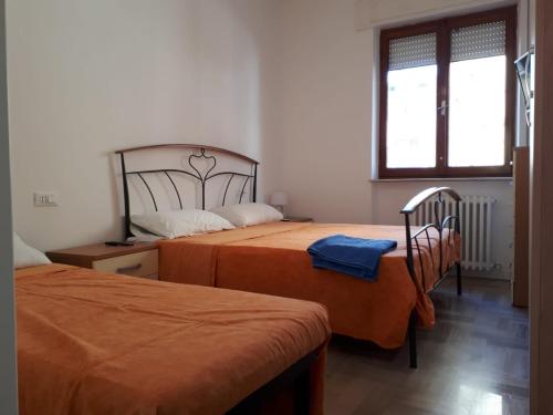 a bedroom with two beds and a window at Appartamento rimodellato seconda fila mare centro di Cupra Marittima in Cupra Marittima