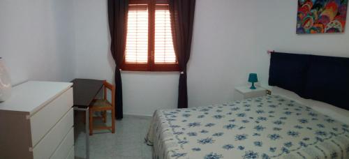 a small bedroom with a bed and a window at Ancilinas House in Castellammare del Golfo