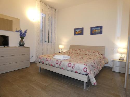 ラ・スペツィアにあるLoft La Conchigliaのベッドルーム(ベッド1台、ドレッサー、テレビ付)