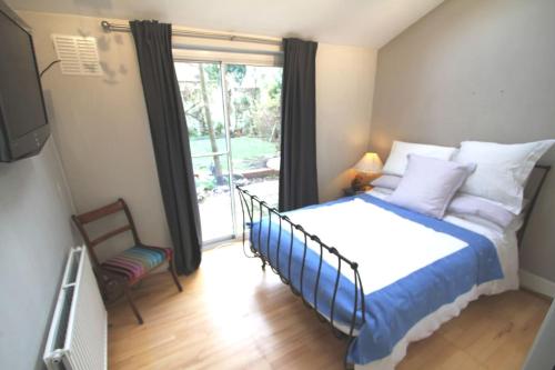 um quarto com uma cama e uma porta de vidro deslizante em SW4 Apartment Clapham Common em Londres