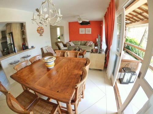 comedor y sala de estar con mesa de madera y sillas en Casa Ilhabela Lado Sul - Próx. Praia do Curral, en Ilhabela