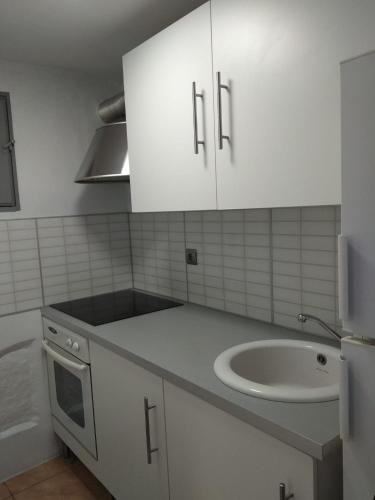 a kitchen with white cabinets and a sink at R&G SALOU CENTER in Salou
