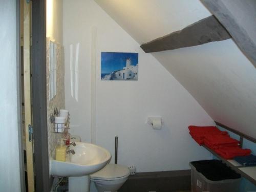 un bagno bianco con lavandino e WC di Stone Cottage a Ménéac