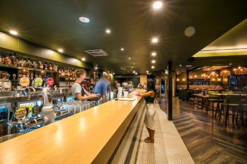 a woman standing at a bar in a restaurant at Nightcap at Caringbah Hotel in Caringbah