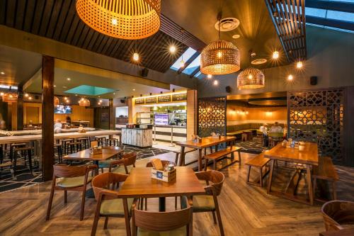 a restaurant with wooden tables and chairs and a bar at Nightcap at Caringbah Hotel in Caringbah