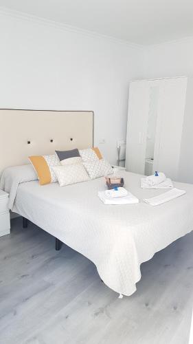 a large white bed with two towels on it at Casa Botes in Cuenca