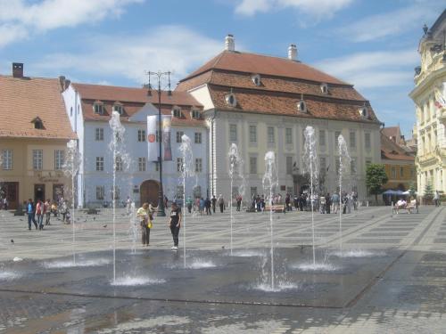a fountain in the middle of a square with a building at MyContinental Sibiu in Sibiu