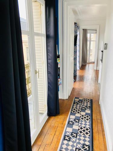 a hallway with blue walls and a door and a rug at Le cœur de Troyes - Appartement & Studio in Troyes